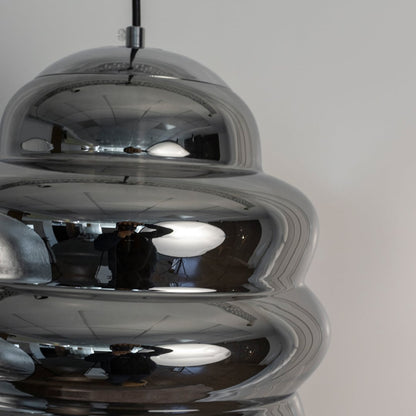 Closeup of ripple chrome pendant light highlighting smooth metallic ripples and high-gloss reflective finish.