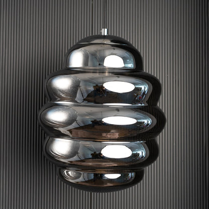 Ripple chrome pendant light turned off against black background showcasing modern craftsmanship and reflective depth.