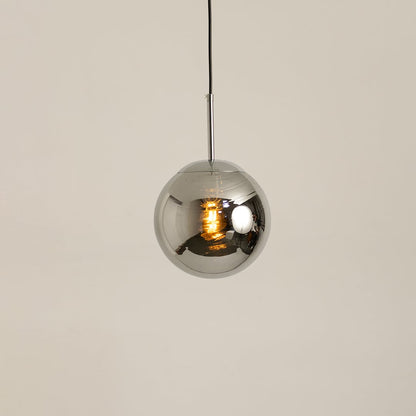 Chrome metal sphere pendant glowing softly on a white background for modern ceiling lighting decor.