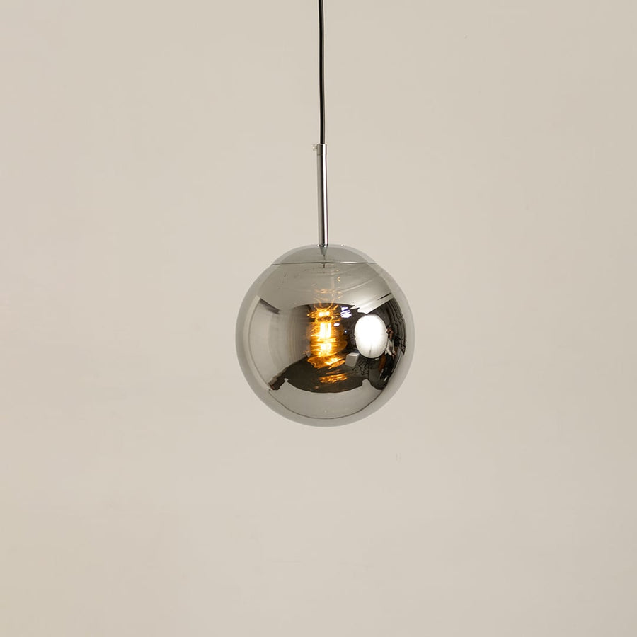 Chrome metal sphere pendant glowing softly on a white background for modern ceiling lighting decor.