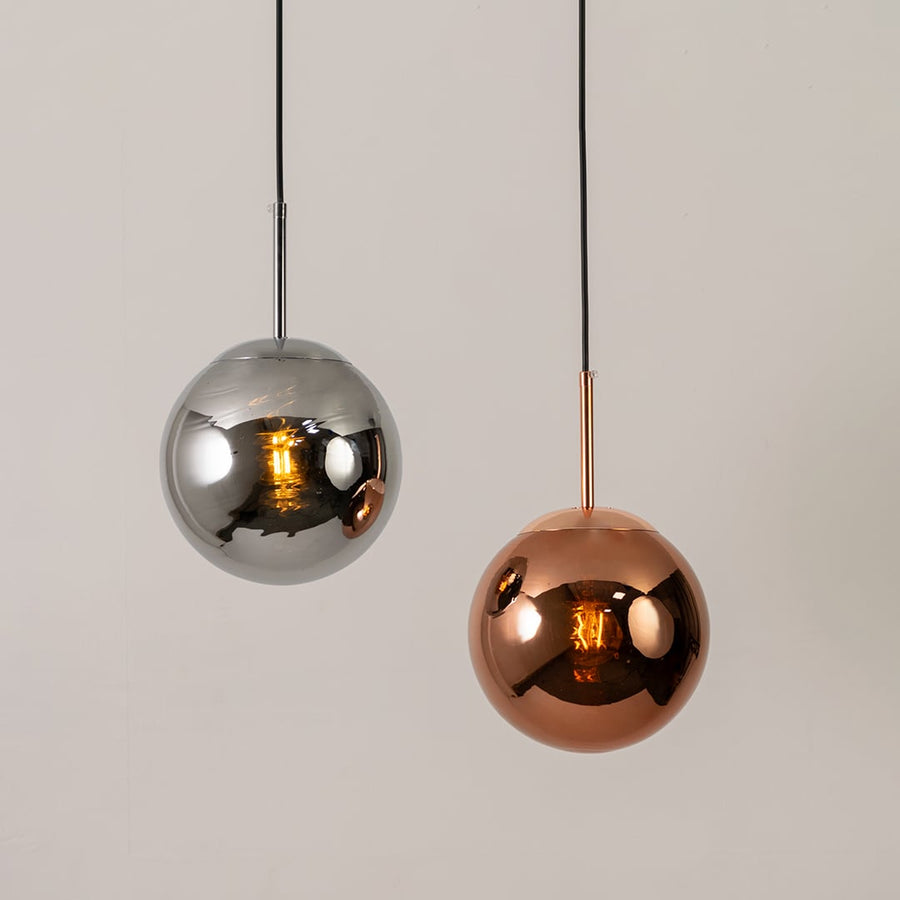 Copper hanging sphere light shown in a styled grouping for modern interior ceiling lighting inspiration.