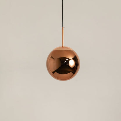Copper spherical pendant light displayed off on a white background highlighting its modern reflective finish.