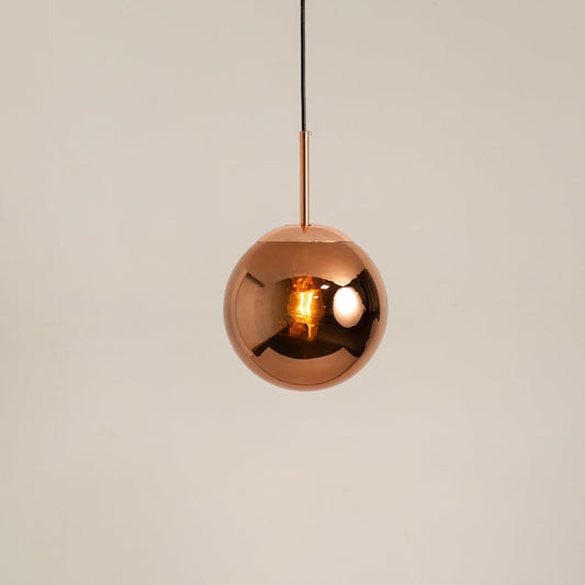 Copper metal spherical pendant light glowing on a clean white background for modern ceiling decor focus.