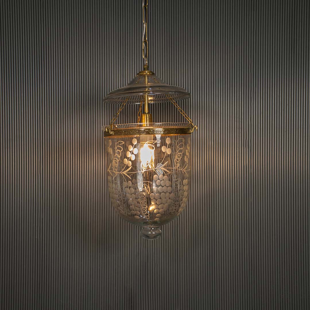 Antique brass and clear glass lantern pendant light adding timeless elegance to luxurious interiors.