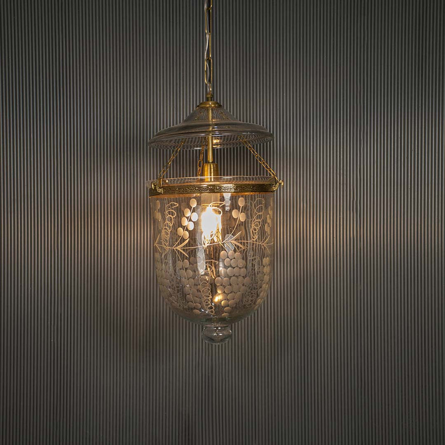 Antique brass and clear glass lantern pendant light adding timeless elegance to luxurious interiors.