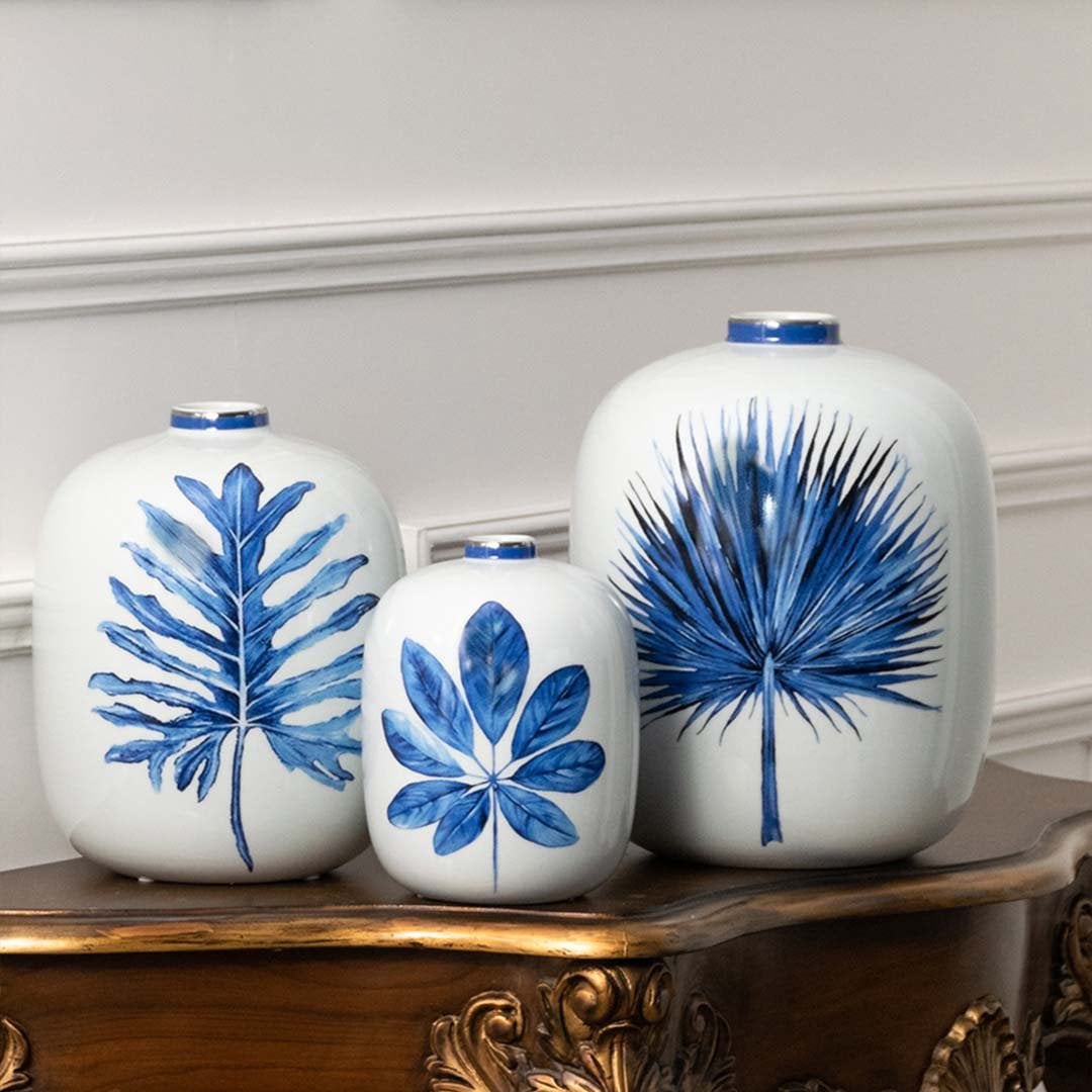 White ceramic jars with blue botanical artwork placed on a wooden console offering a vibrant natural décor accent that enhances home interiors beautifully.