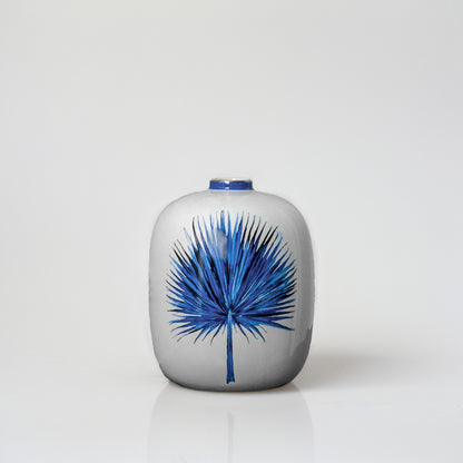 White ceramic decorative vase with blue botanical artwork for sophisticated shelf styling and modern home decor.