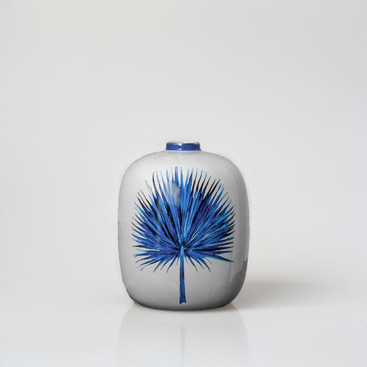 White ceramic decorative vase with blue botanical artwork for sophisticated shelf styling and modern home decor.