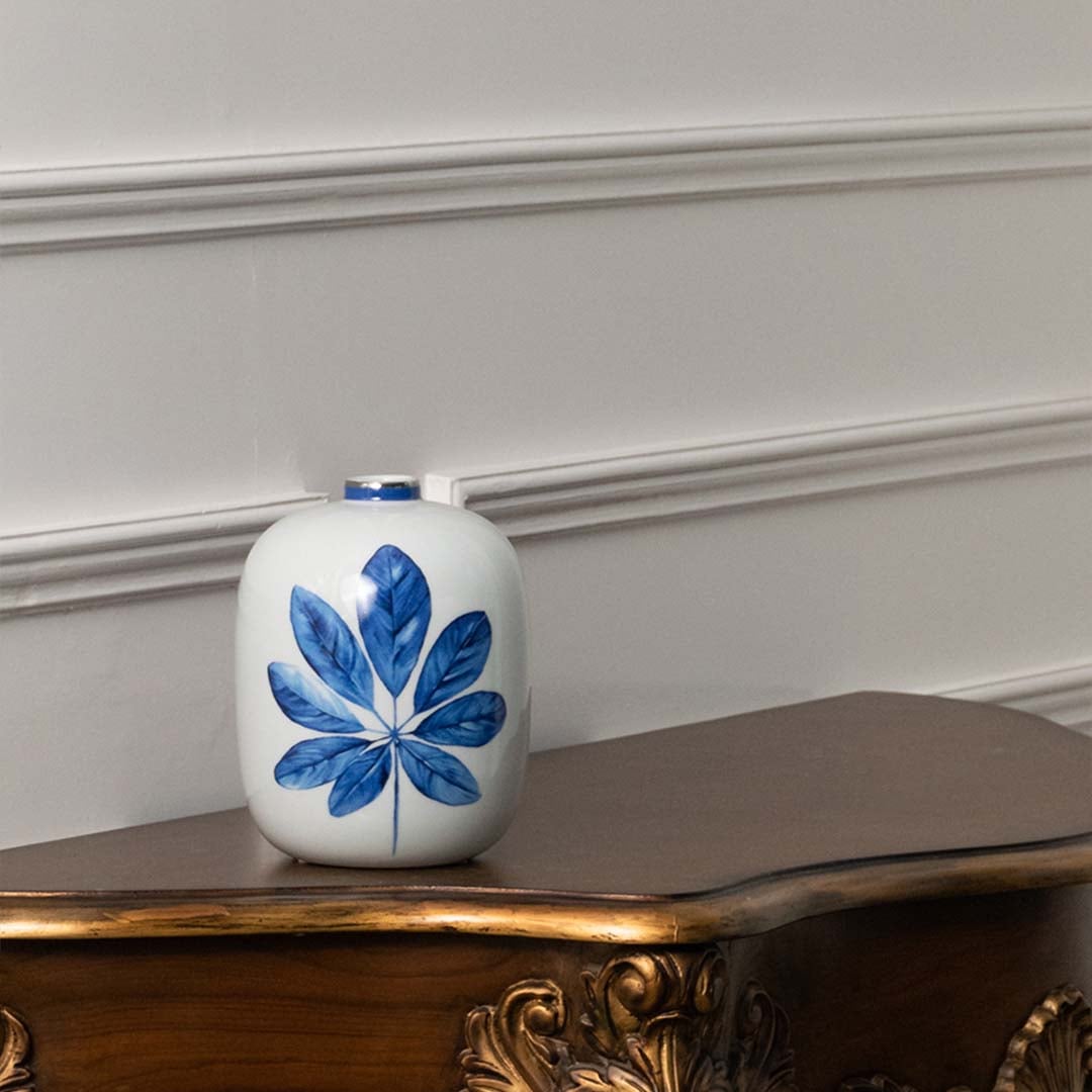 White ceramic jar with blue flower artwork in a front view ideal for clean minimalist décor styling and elegant tabletop placement.