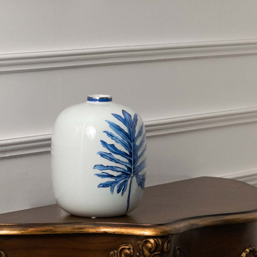 White ceramic jar with blue leaf artwork in a front view perfect for modern décor styling and elegant home accents.