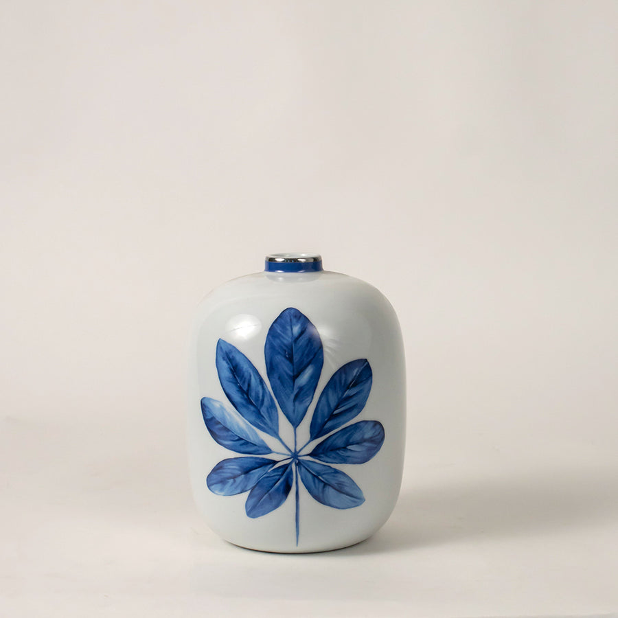 White ceramic decorative jar with blue botanical artwork for contemporary tabletop styling and elegant home decor displays.