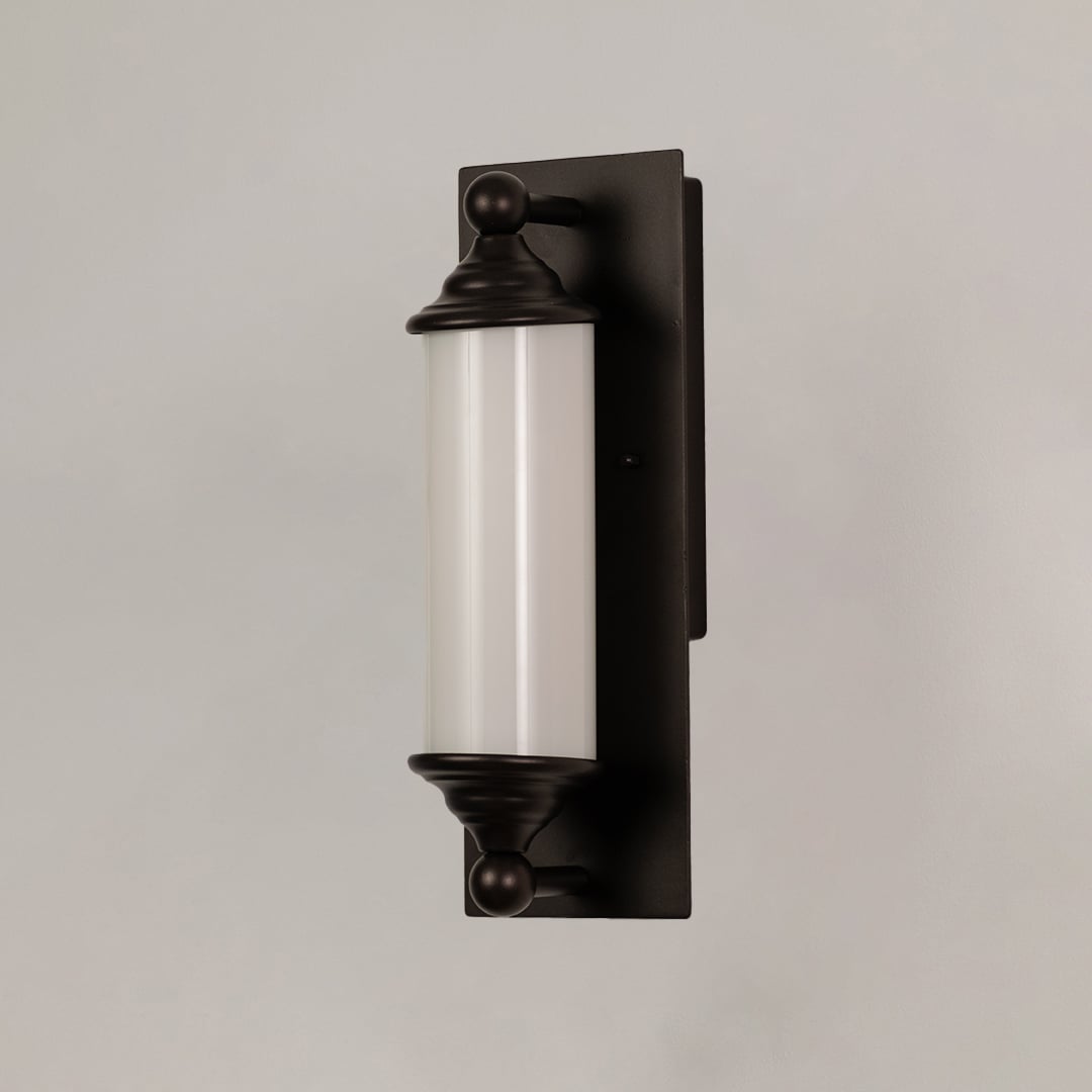 Black metal wall sconce with frosted glass tube shown on white background ideal for hallways and entry decor.