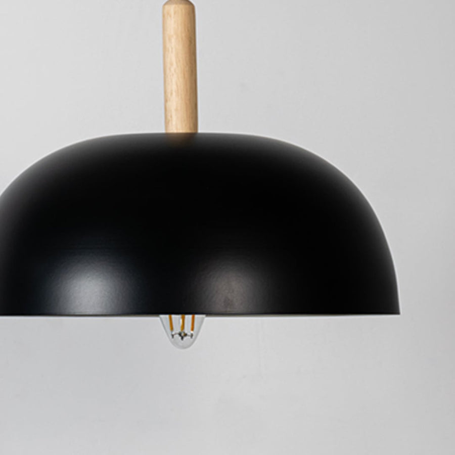 Closeup of black dome pendant ceiling light with wooden accent showing matte finish for modern dining kitchen and cafe lighting decor.