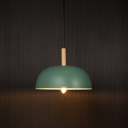 Green dome pendant ceiling light with wooden accent illuminated on back background for modern dining cafe and home interior ceiling lighting.