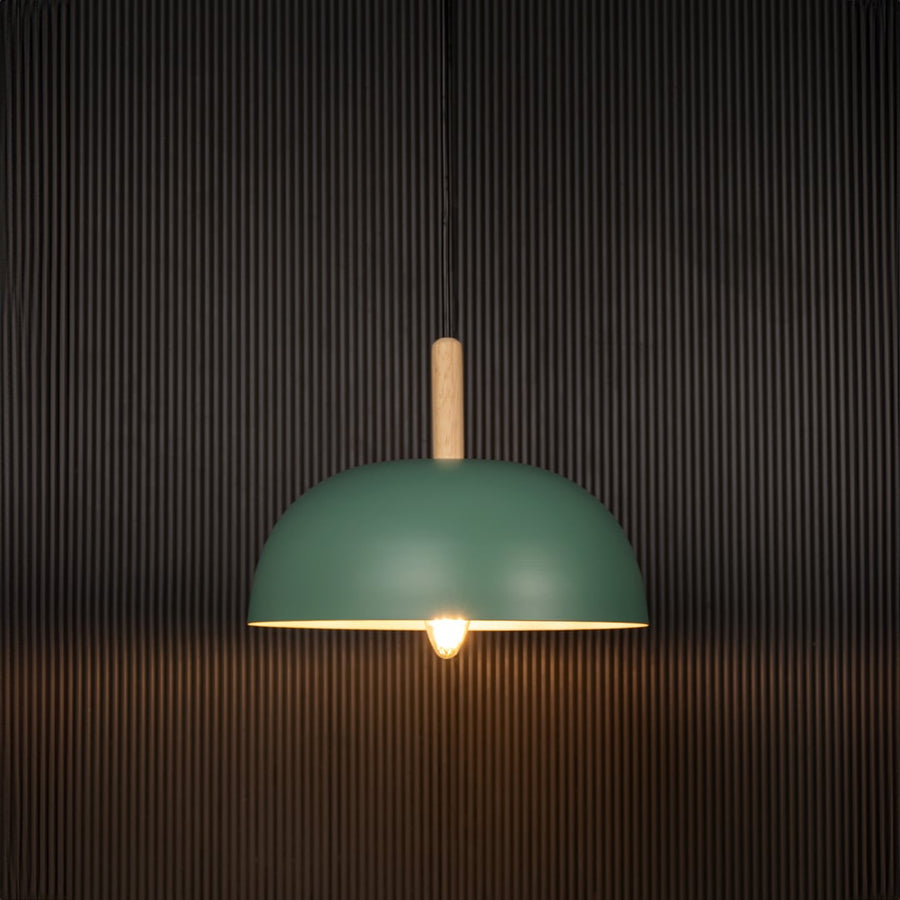 Green dome pendant ceiling light with wooden accent illuminated on back background for modern dining cafe and home interior ceiling lighting.
