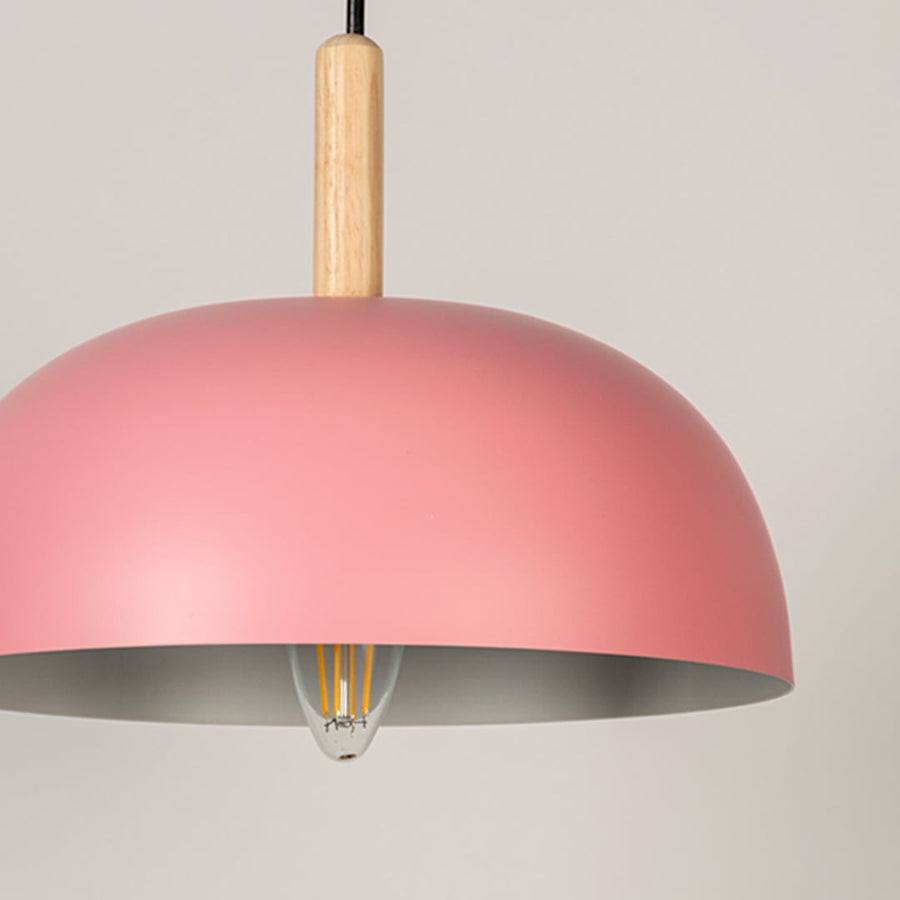 Closeup of pink dome pendant ceiling light with wooden accent showing matte finish for dining room kitchen and modern cafe lighting.
