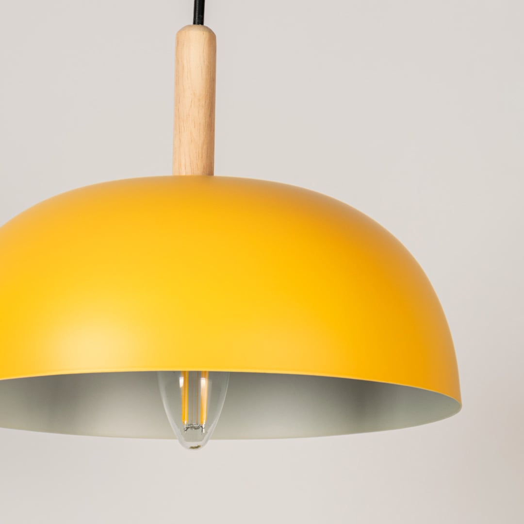 Closeup view of yellow dome pendant lamp with smooth matte finish and wooden holder creating an elegant hanging ceiling light fixture.