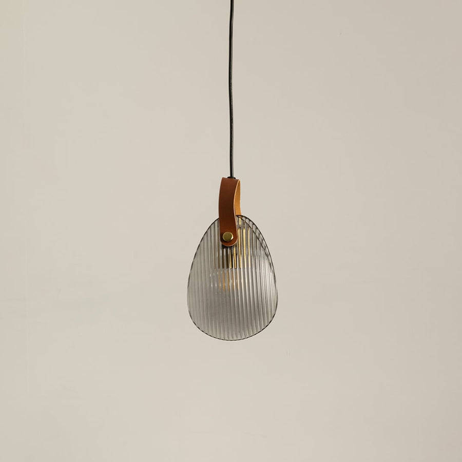 Ribbed glass pendant light with leather strap displayed off on a clean white background for minimalist lighting style.