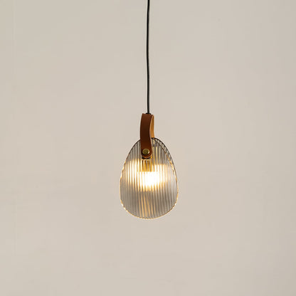 Ribbed glass pendant light with leather strap glowing on a white background for modern hanging lighting decor.