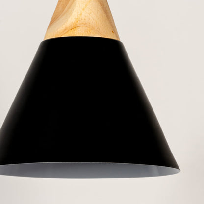 Closeup of black pendant light with wooden top and conical metal shade showing elegant modern lighting design.