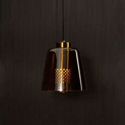 Gold metallic pendant light illuminated on black background creating a rich warm glow and bold reflective look for modern interior lighting.