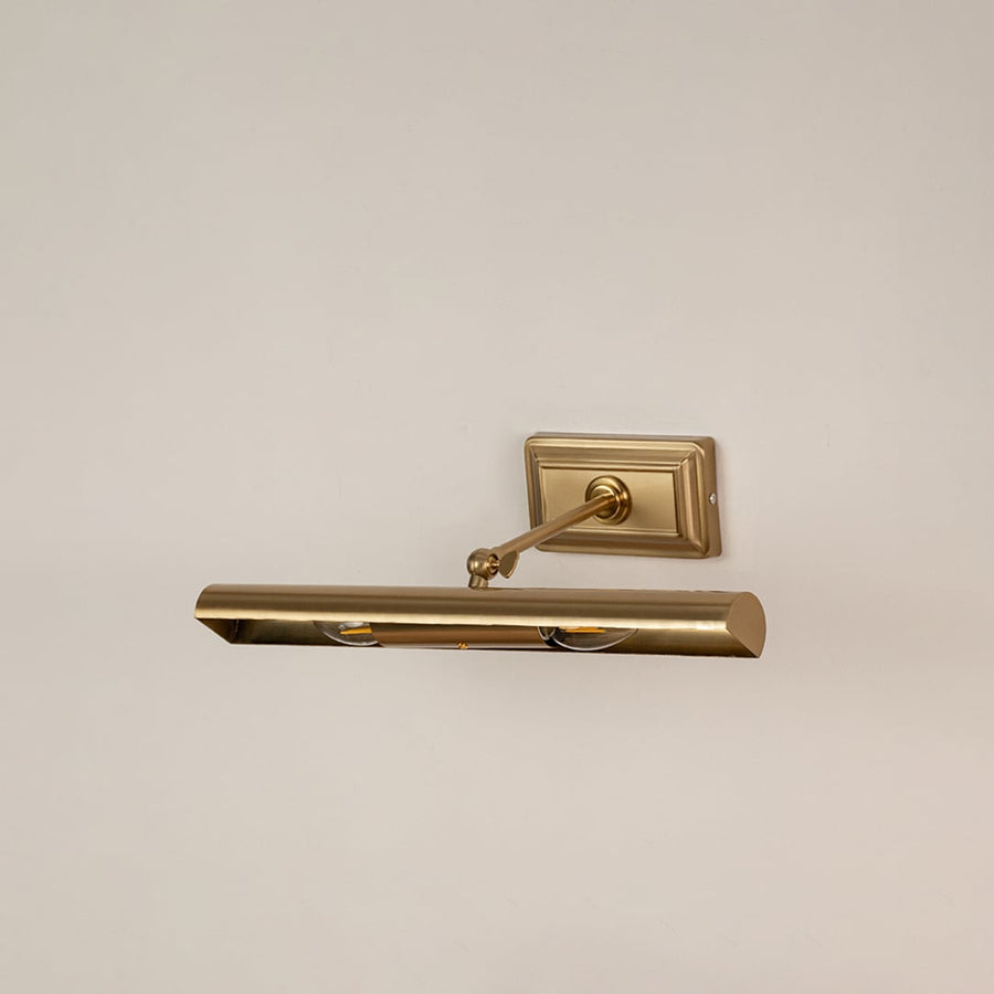 Gold metal picture light on a white background with the light off showcasing its classic adjustable design.