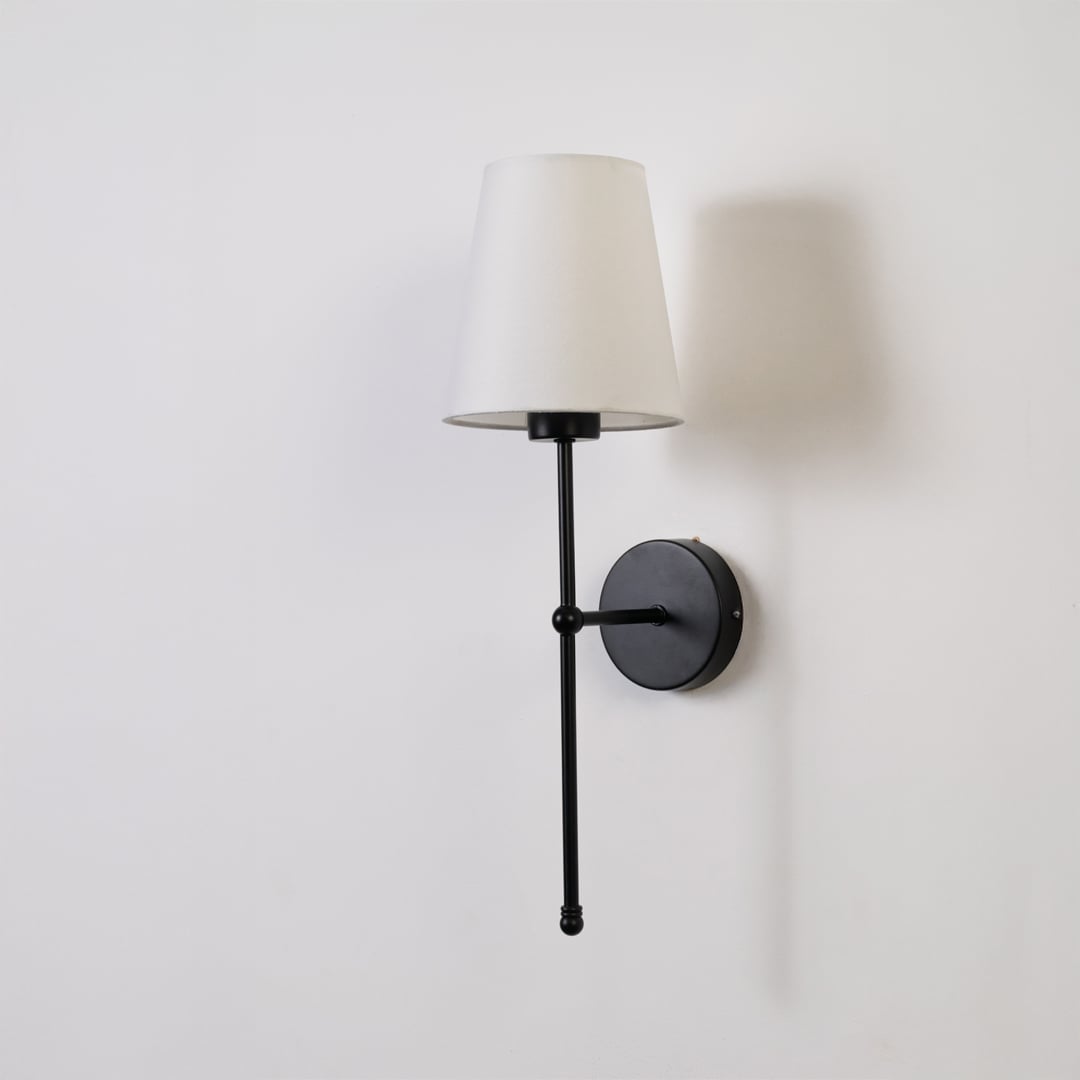 Black metal wall light with white shade displayed on a white background in a clean minimal look.