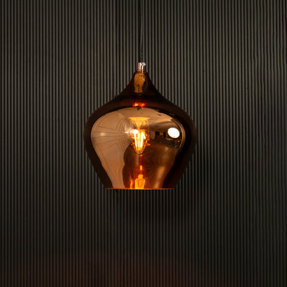 Gold reflective pendant light glowing on black background creating dramatic warm lighting and a bold modern metallic decorative look.