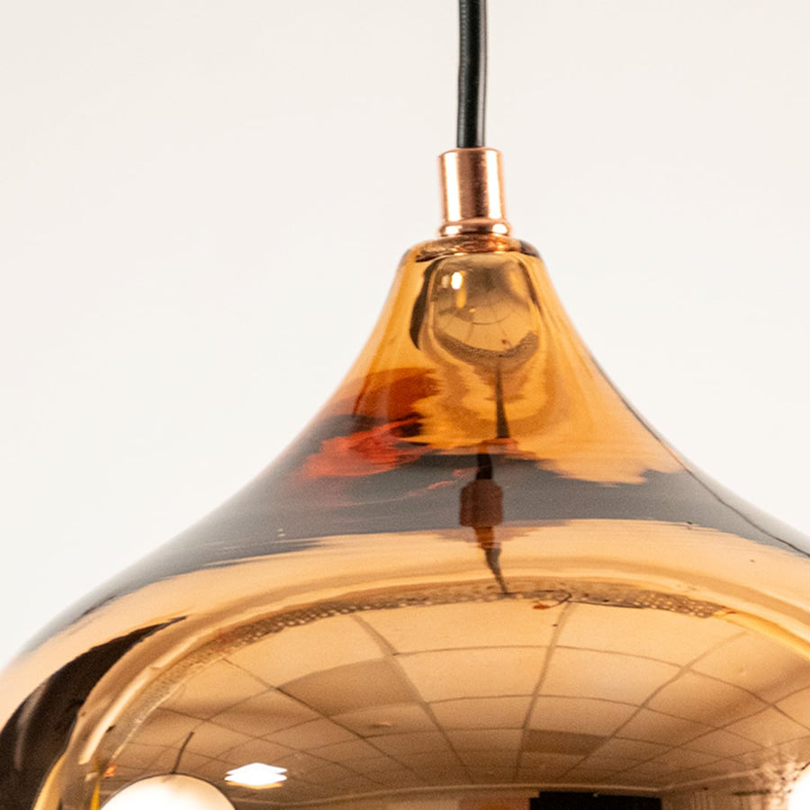 Closeup of gold reflective pendant light showing glossy metal finish and smooth curved design ideal for stylish modern interior lighting.