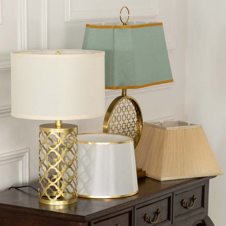 White shade gold lattice table lamp on wooden sideboard with light off for chic contemporary home décor.
