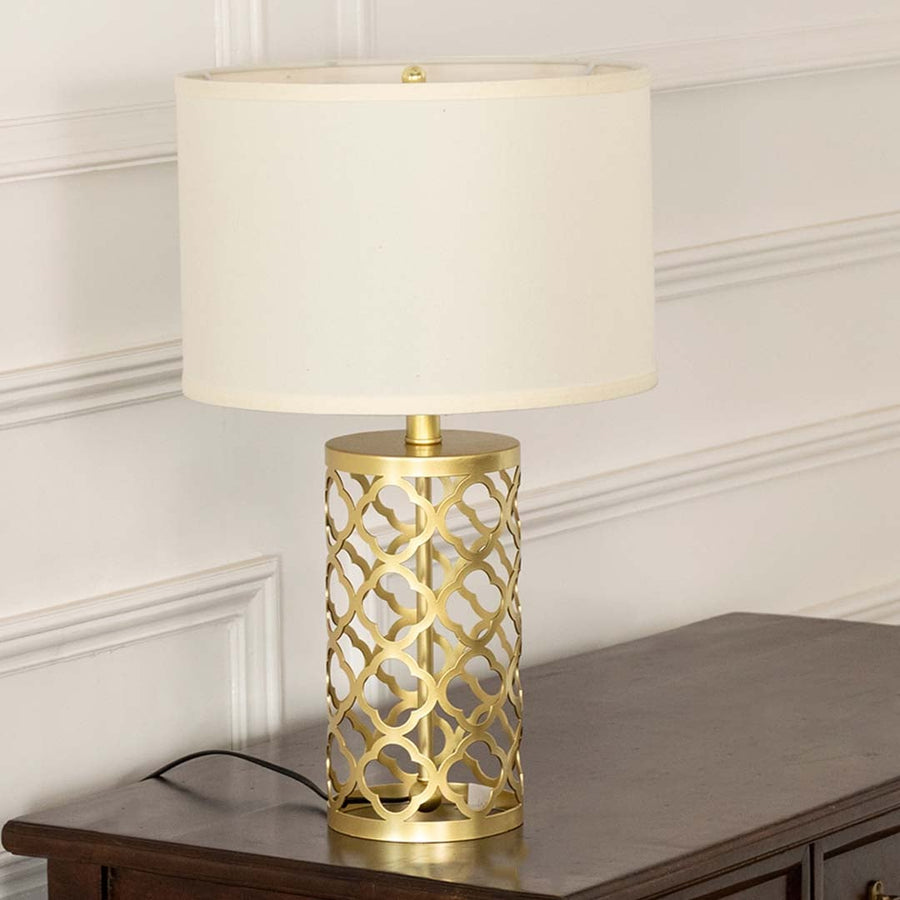 White shade gold geometric lamp on wooden table with light on and white wall background for chic modern décor.