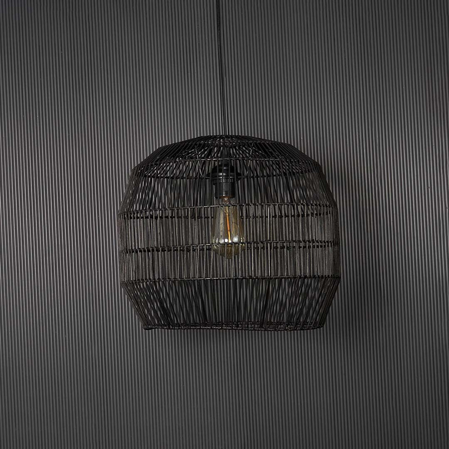 Contemporary black woven pendant light against black background featuring elegant handmade texture and sophisticated design appeal.