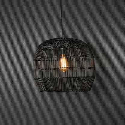 Stylish black rattan pendant light glowing on dark background highlighting intricate weaving and soft ambient illumination.