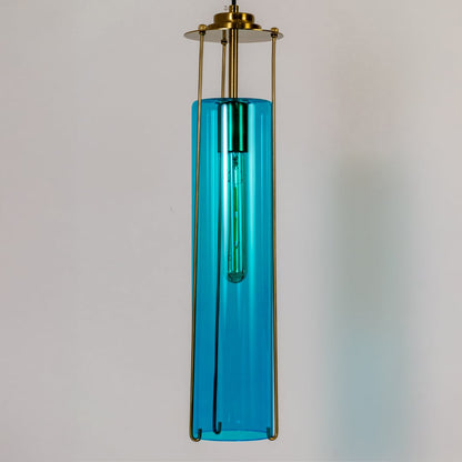 Closeup view of the blue glass pendant light showcasing its glossy finish inner tube bulb and polished brass frame with modern detailing.