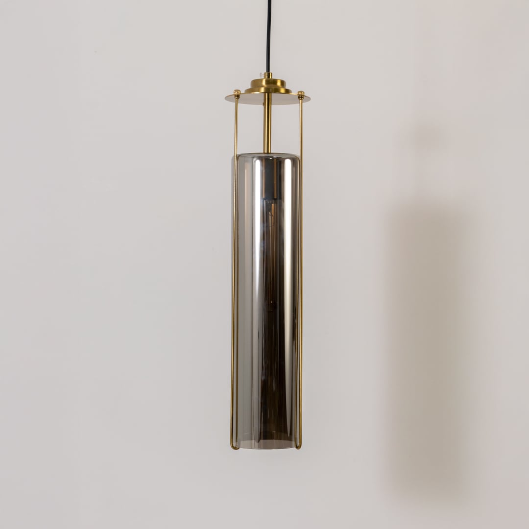 Smoked glass pendant light turned off on a white background showing its tall cylinder shade and refined brass structure in detail.