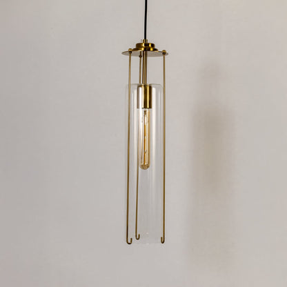 Clear glass pendant light turned off against a white background emphasizing its minimalist cylindrical design and polished brass structure.