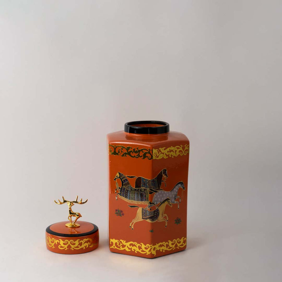 Elegant orange ceramic decor jar with ornate golden lid and artistic horse pattern ideal for classic interiors.