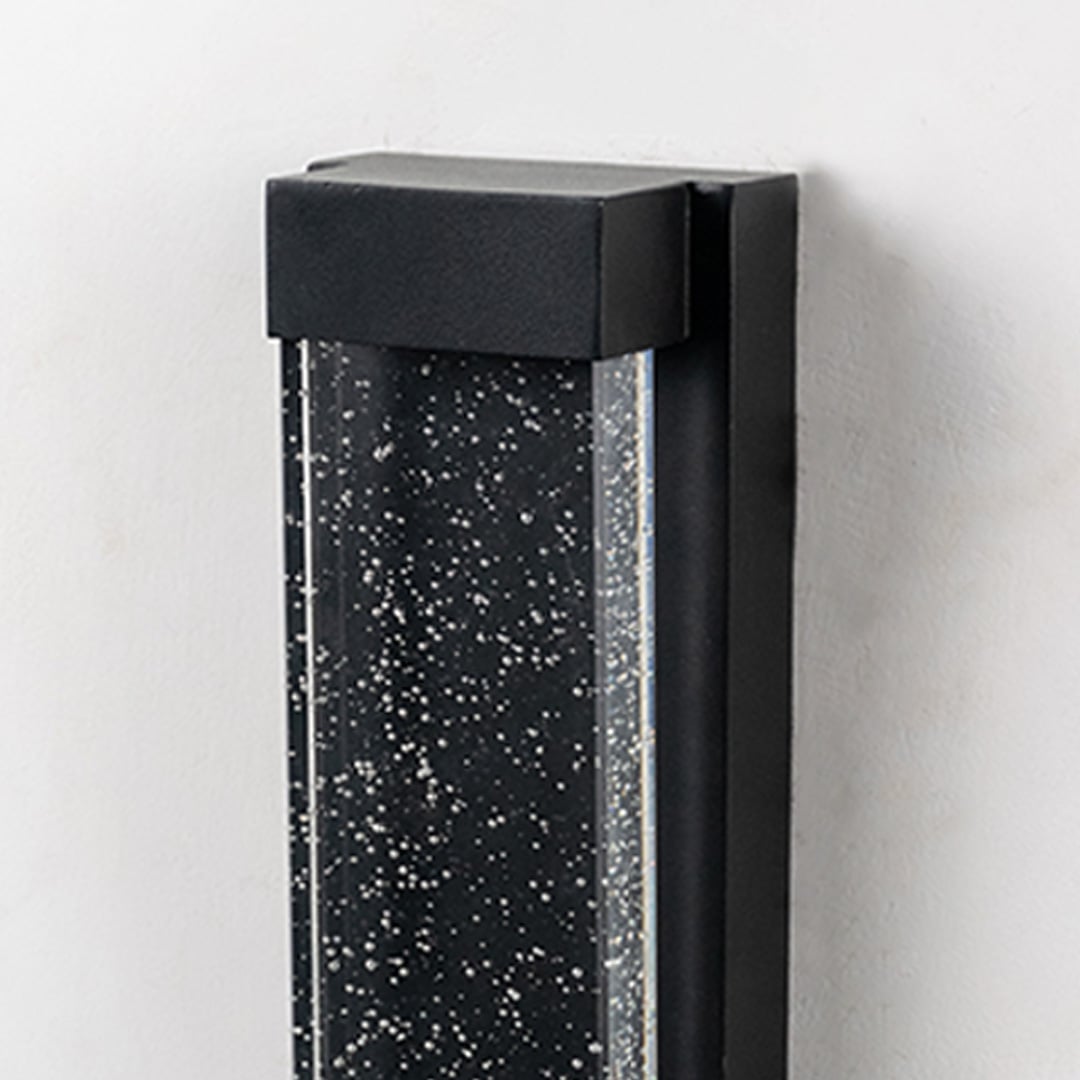 Closeup of wall light featuring frosted bubble glass and modern black frame.