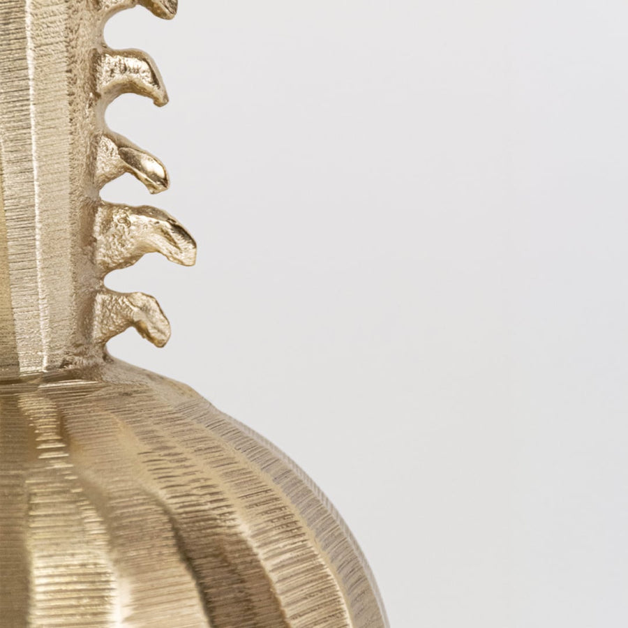 Closeup of gold metal decor object showing textured hammered surface refined detailing and premium craftsmanship for luxury interior styling.
