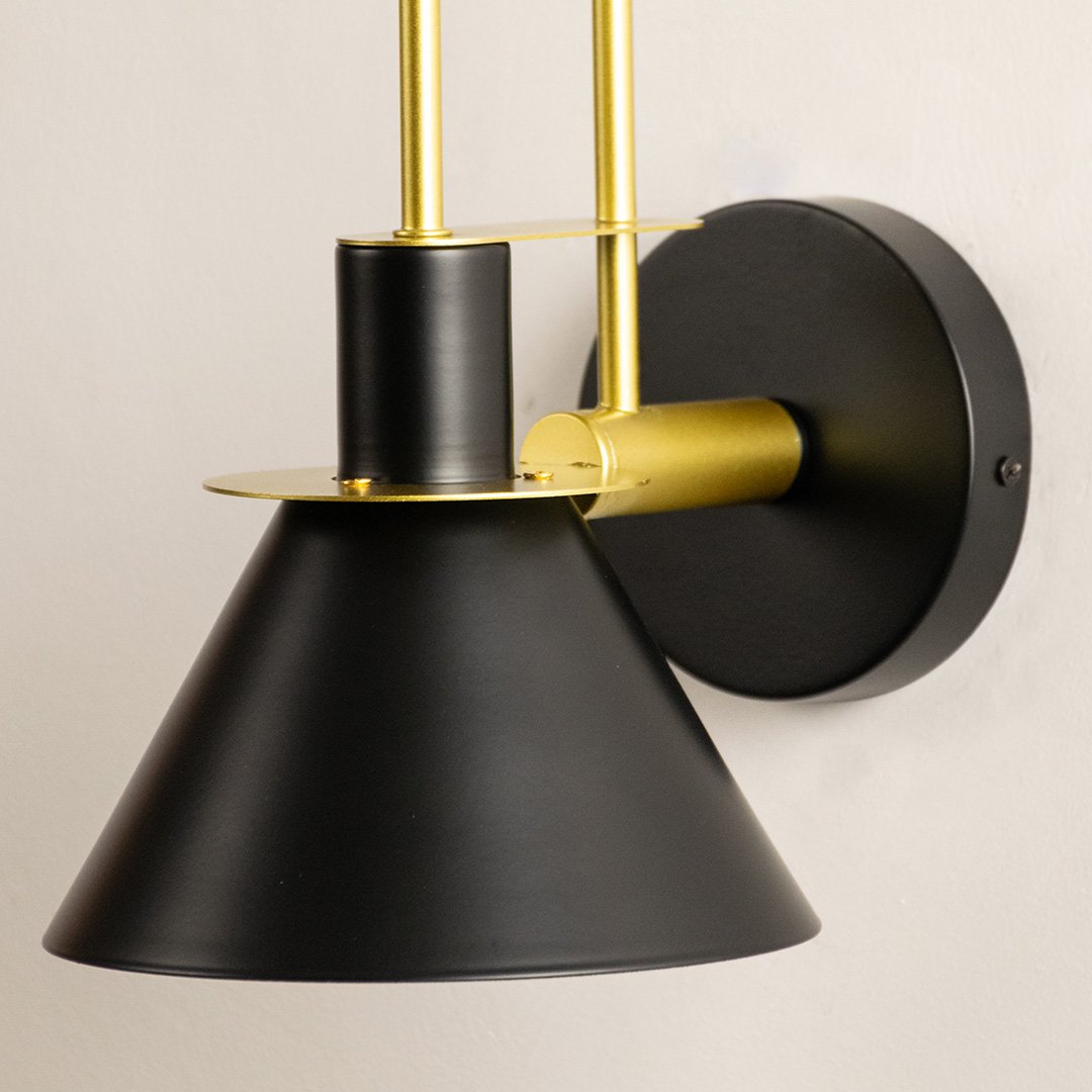 Contemporary black metal wall light with brass detailing for stylish modern bedroom and hallway decor.