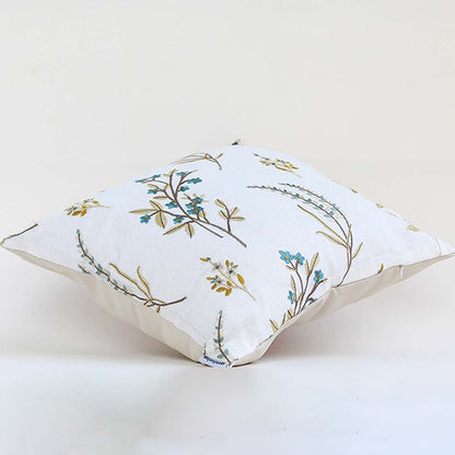 A white background image displaying a botanical embroidered cushion with delicate leaves and floral stitching highlighting the design clearly against a plain backdrop.