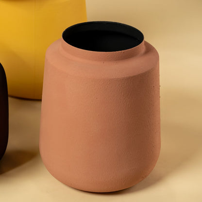 Closeup of terracotta metal textured vase showing its matte surface and rounded shape perfect for modern earthy home styling.
