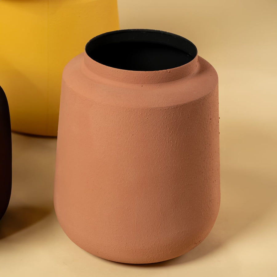 Closeup of terracotta metal textured vase showing its matte surface and rounded shape perfect for modern earthy home styling.