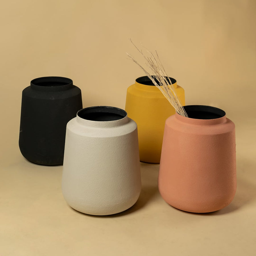 Terracotta metal textured vases arranged together giving a cohesive earthy look ideal for console tables and shelf styling.