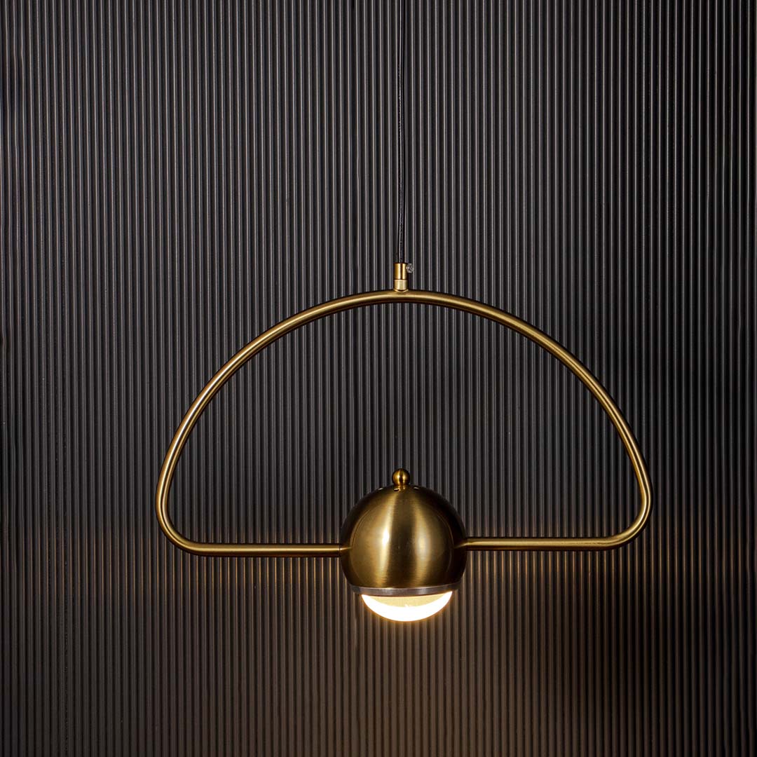 Golden arch pendant light with dome glass glowing warm light stylish modern ceiling lamp perfect for living and bedroom interiors.