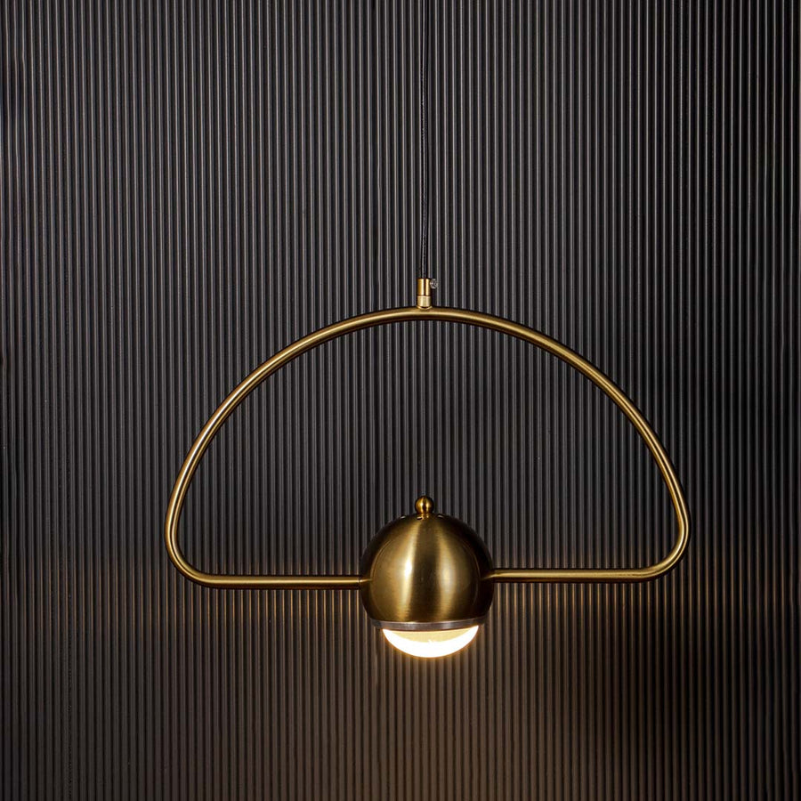 Golden arch pendant light with dome glass glowing warm light stylish modern ceiling lamp perfect for living and bedroom interiors.