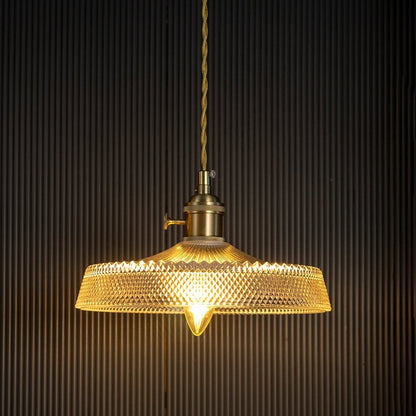 Amber ribbed glass pendant light with gold metal fittings casting a warm glow for elegant interiors.