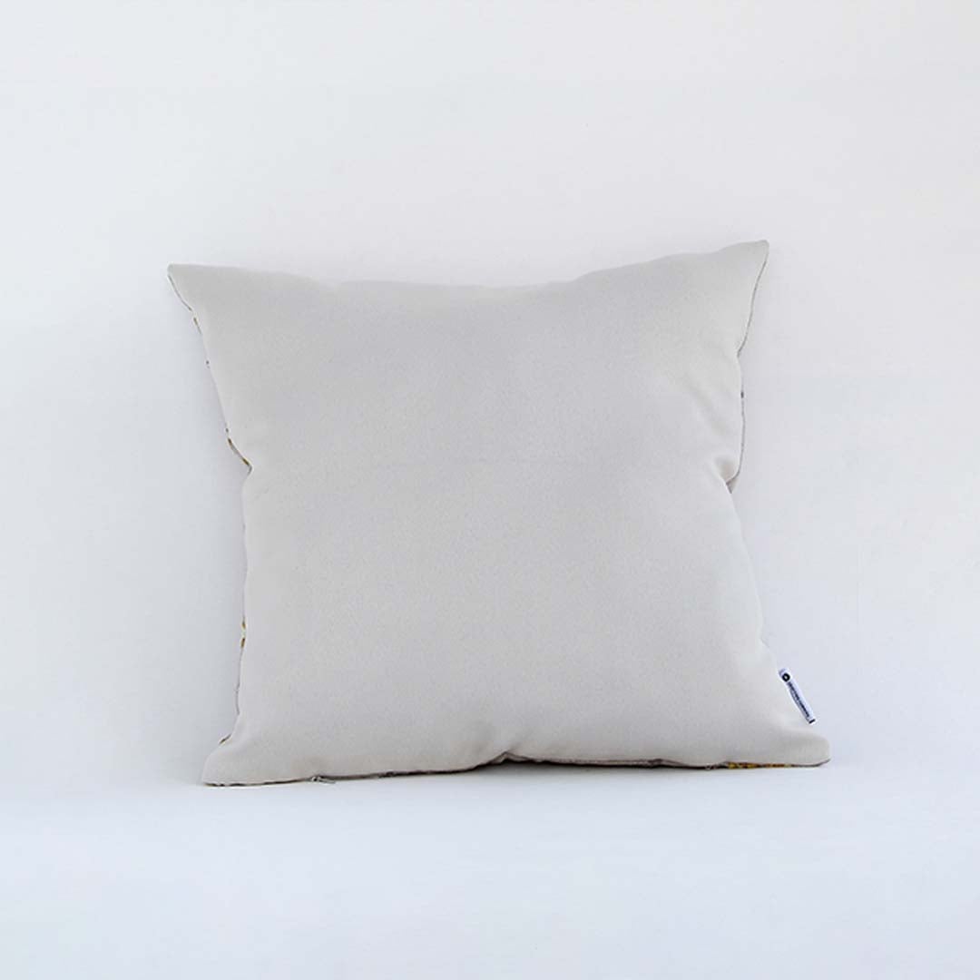 Side view of the geometric embroidered cushion showing its soft filled shape and raised textured pattern.