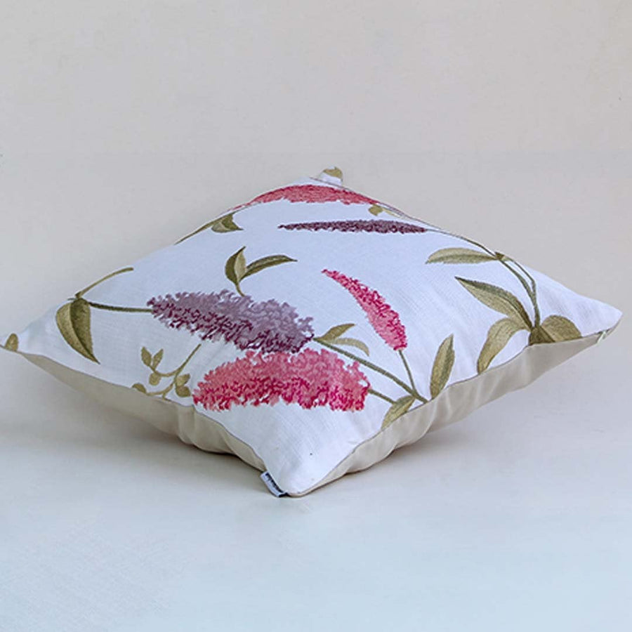 Soft cotton cushion cover with pink floral embroidery displayed at an angle providing a lively nature inspired décor touch with a breathable gentle and skin friendly fabric suitable for modern homes.