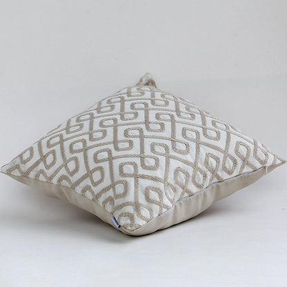 Modern geometric embroidered cushion placed against a white background highlighting its elegant woven design.